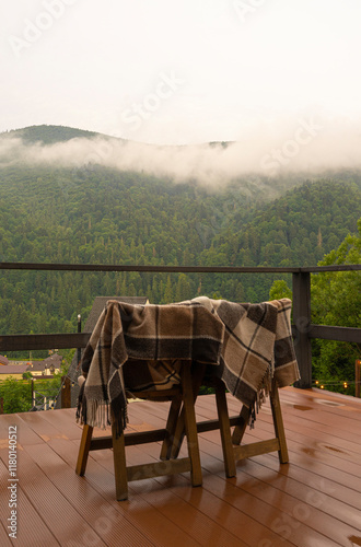 Wooden chairs with a blanket on the background of a mountain landscape, vacation in the mountains