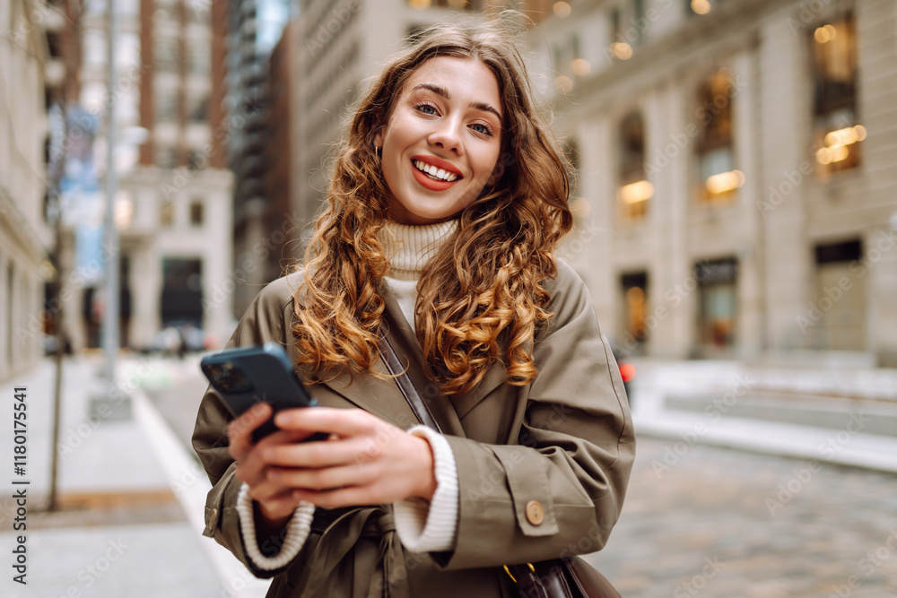 Obraz premium Portrait of happy woman with smartphone in the street city. Concept of vacation, blogging, technology, weekend.