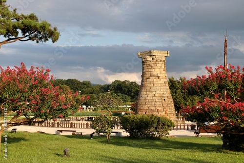 Ancient Stone Observatory Tower Cheomseongdae Surrounded by Blooming Trees in Gyeongju, South Korea - Historical Landmark in a Serene Park Setting