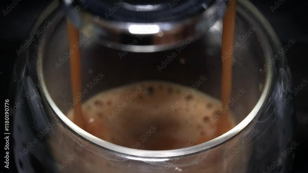 Gros plan d'un expresso versé dans une tasse, depuis une machine à café
