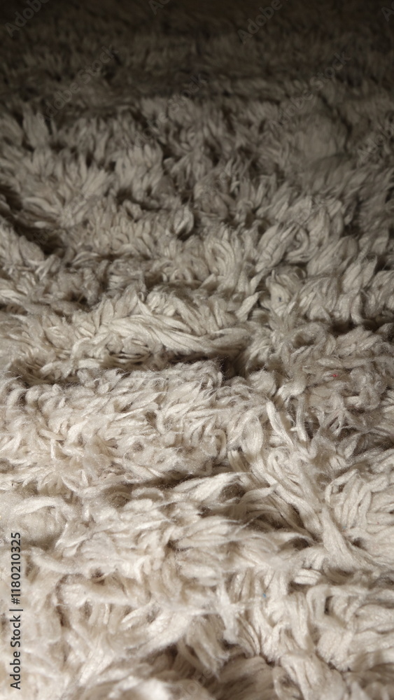 Close-up texture of a fluffy cream-colored fabric with intricate fiber patterns. Close-up texture of a fluffy cream-colored fabric with intricate fiber patterns.