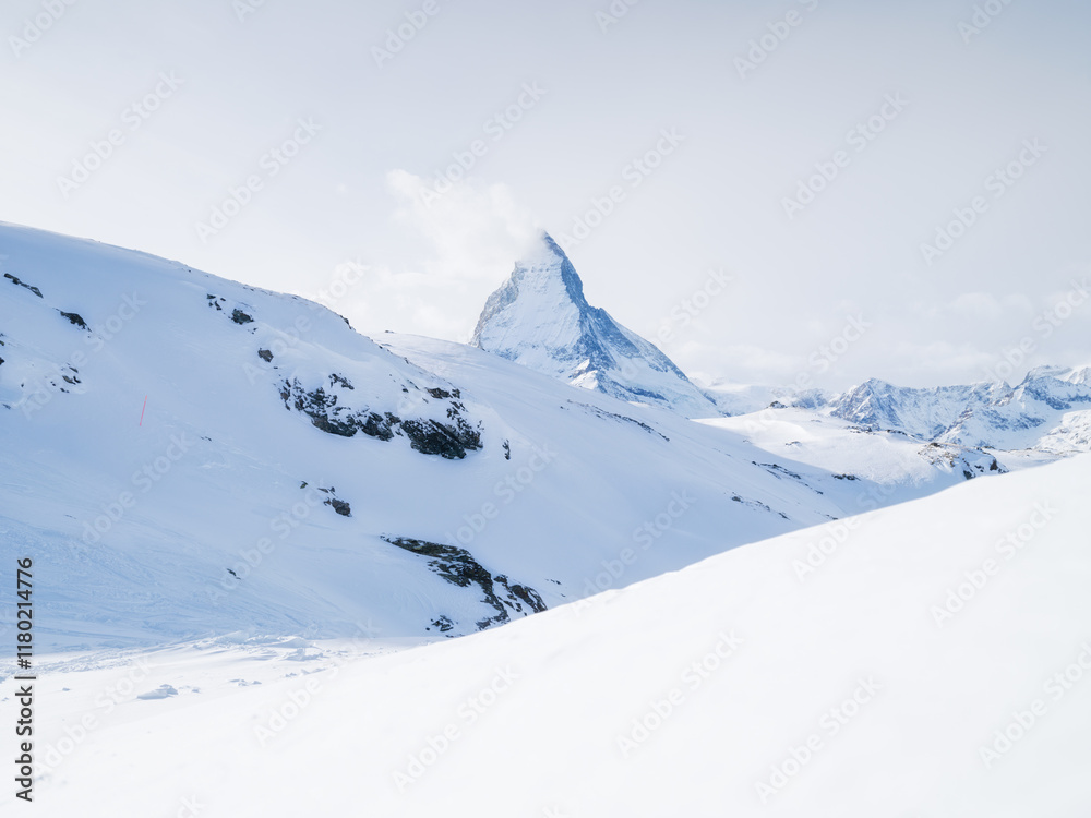 Fototapeta premium Matterhorn, Switzerland. Winter mountain landscape. A place for skiing. Zermatt ski resort. High rocks and snow. Mountain scene in Switzerland. Photo for postcards, backgrounds, wallpapers.