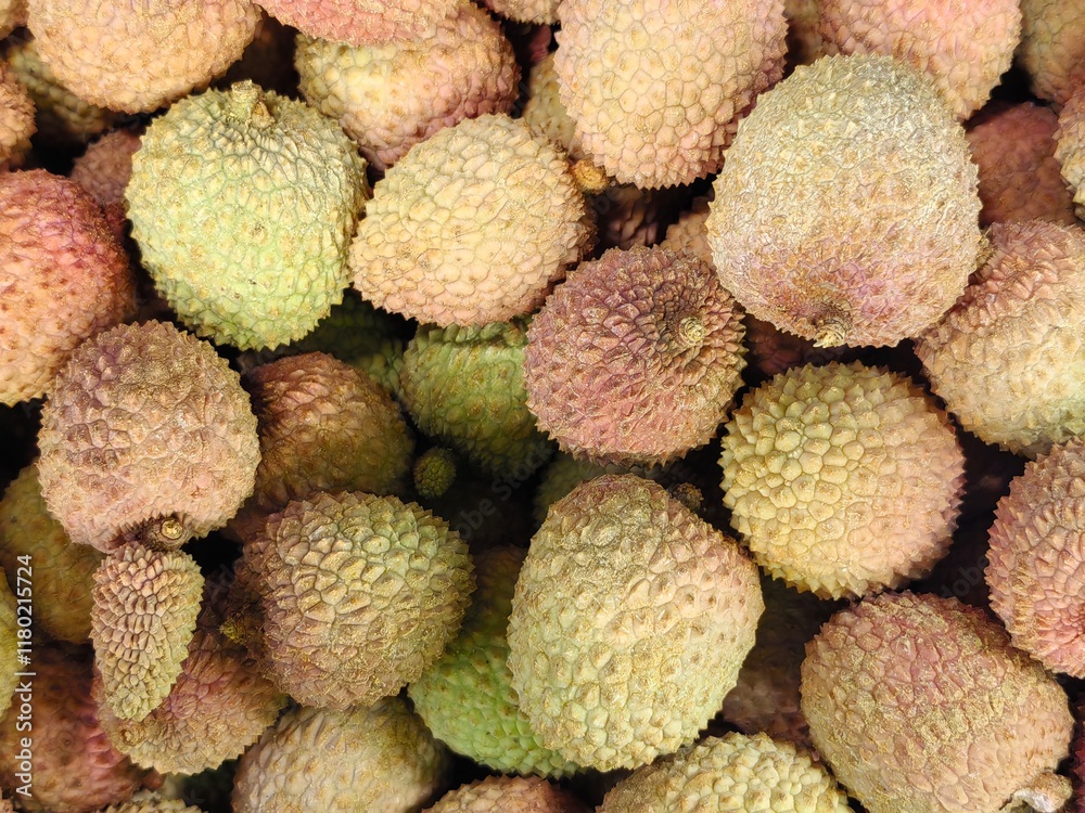 A large quantity of lychees are lying in a container on the counter A large quantity of lychees are lying in a container on the counter
