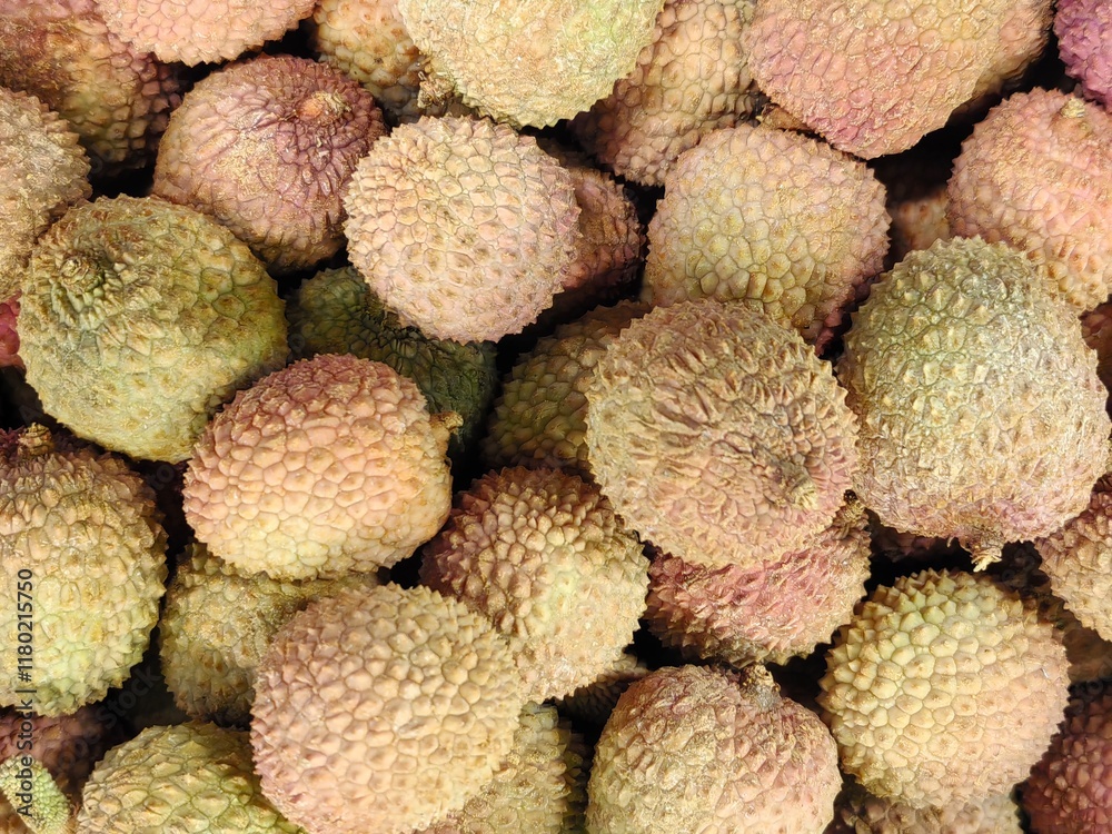 A large quantity of lychees are lying in a container on the counter A large quantity of lychees are lying in a container on the counter