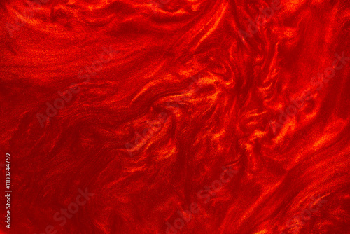 Shimmering red abstract background. Liquid glitter paint texture waves and swirls. Beautiful shiny red glitter texture. Metallic paint close-up as a holiday background.