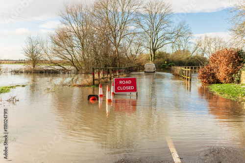 Severe flooding on the B1223 road between the villages of Ryther and Cawood in North Yorkshire with Road Closed sign and a vehicle ignoring the warning sign and driving through the water.  Copy space
