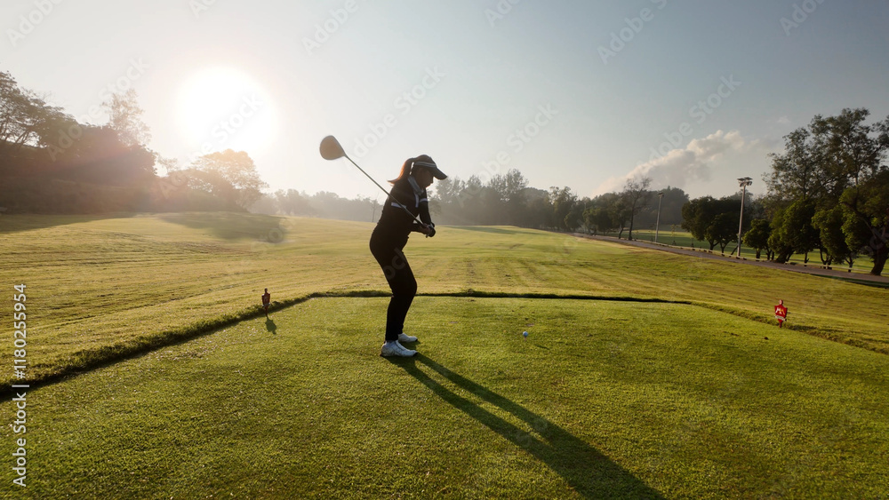 Woman playing golf on beautiful course , swinging and hitting golf ball , luxury vacation