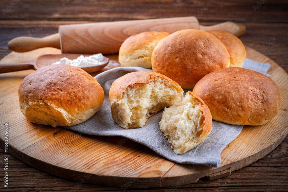 Freshly baked milk rolls offered as close-up on a rustic wooden tray Freshly baked milk rolls offered as close-up on a rustic wooden tray