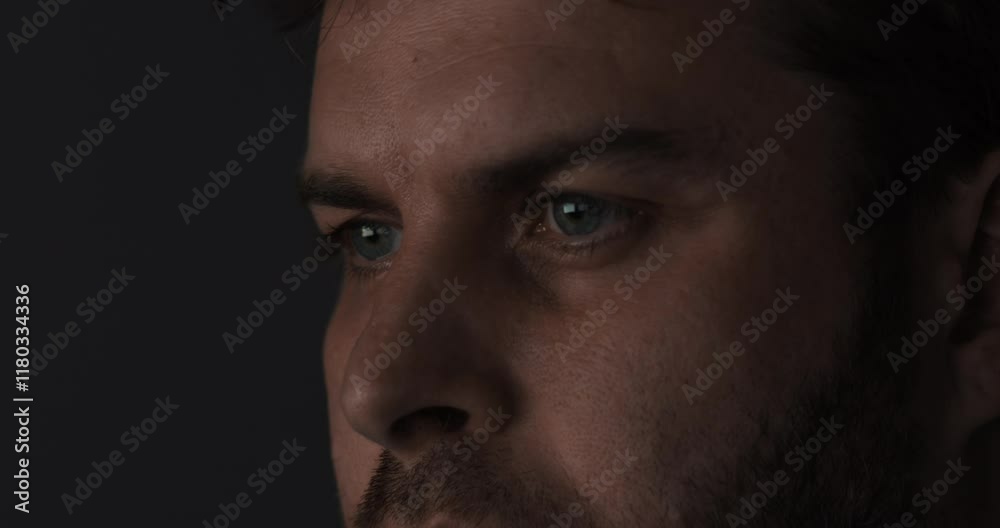 An Intense CloseUp Capture of a Pensive, Thoughtful Man in Dramatic Low Light Setting An Intense CloseUp Capture of a Pensive, Thoughtful Man in Dramatic Low Light Setting