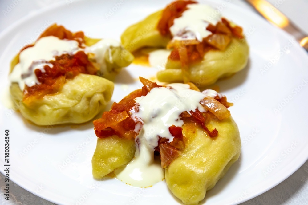 Classic Ukrainian food, perohê or veréneki stuffed with potatoes and cottage cheese and cooked, served with different types of sauce and salted and sour cream Classic Ukrainian food, perohê or veréneki stuffed with potatoes and cottage cheese and cooked, served with different types of sauce and salted and sour cream
