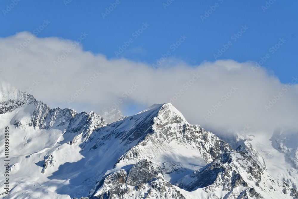 French alps on a sunny day under the clouds by winter covered with snow French alps on a sunny day under the clouds by winter covered with snow