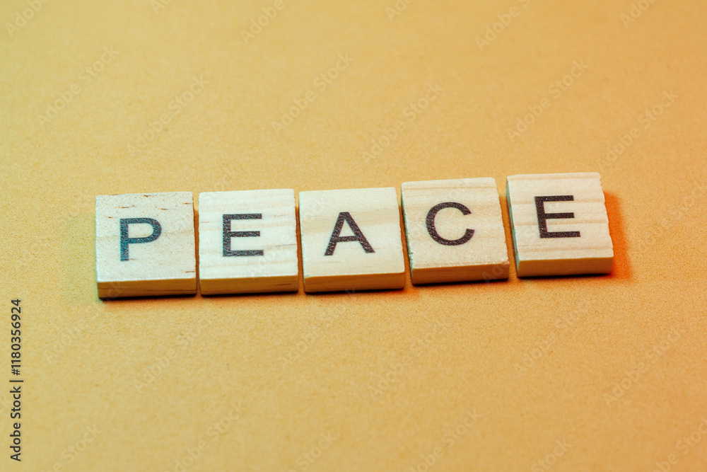 Wooden blocks spell peace on a textured yellow background Wooden blocks spell peace on a textured yellow background