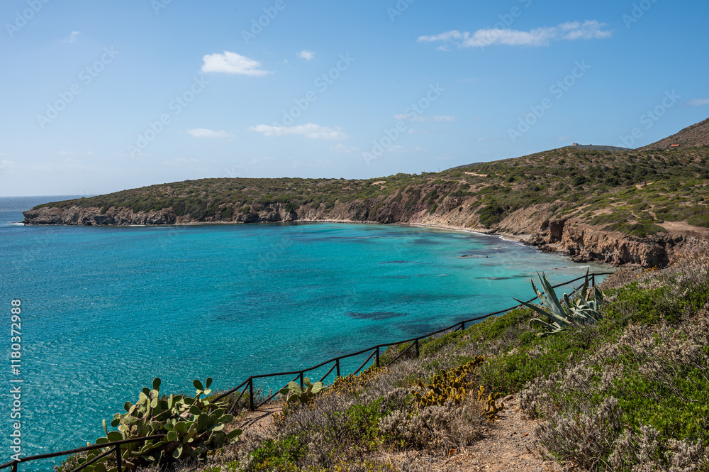 Landscape of the coast of the island of Sant'Antioco with the turquoise sea and the red cliffs on a sunny day