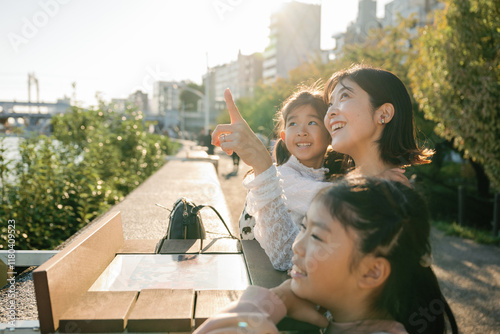 Photography Happy asian family pointing at something while sightseeing in a city park in Tok