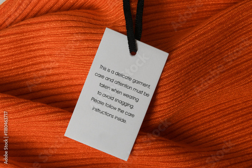 Close up of luxury clothing hang tag. Delicate garment swing tag. Laundry care washing instructions clothes label.	 photo