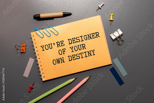 Arrow on asphalt road written word you're designer of your own destiny
