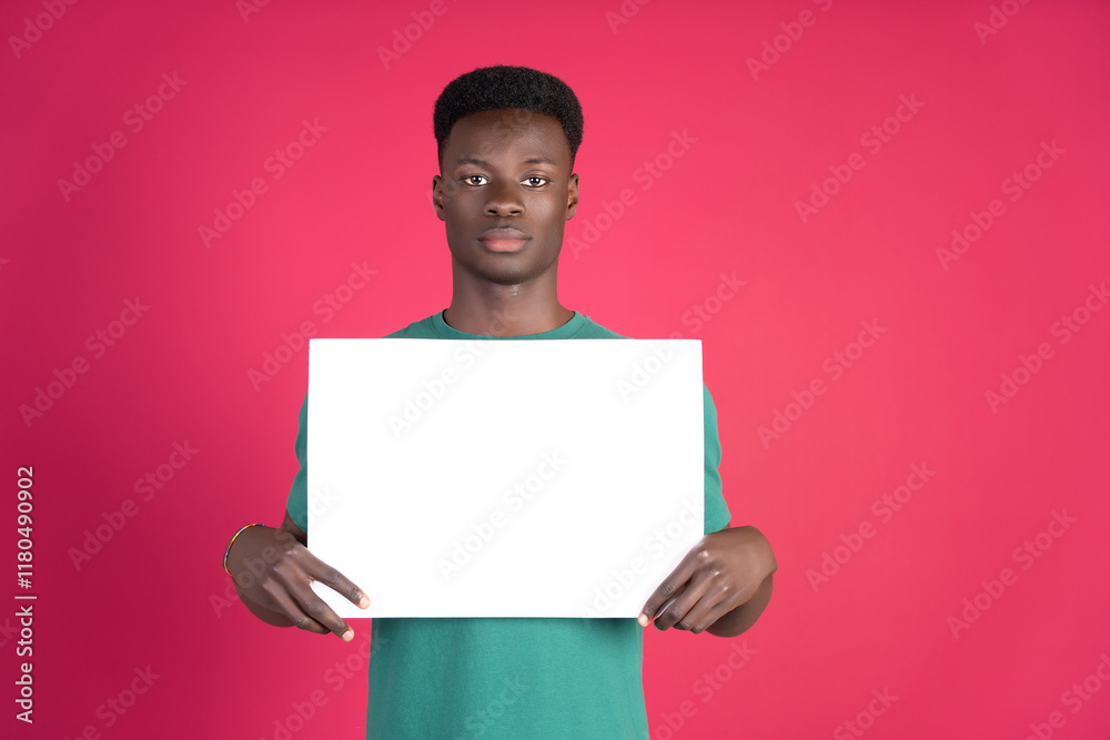 Young man showing blank placard against colorful background Young man showing blank placard against colorful background