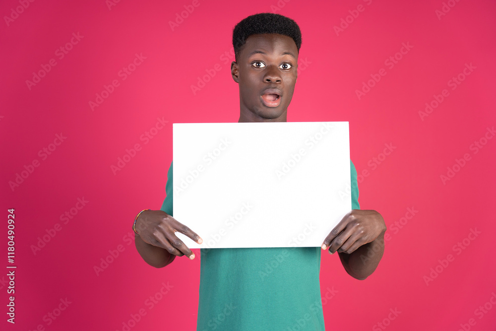 Surprised young man showing blank whiteboard on pink background Surprised young man showing blank whiteboard on pink background