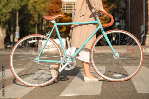 Young woman with bicycle walking across pedestrian crossing