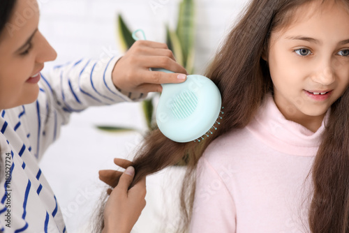 Mother brushing daughter's ...