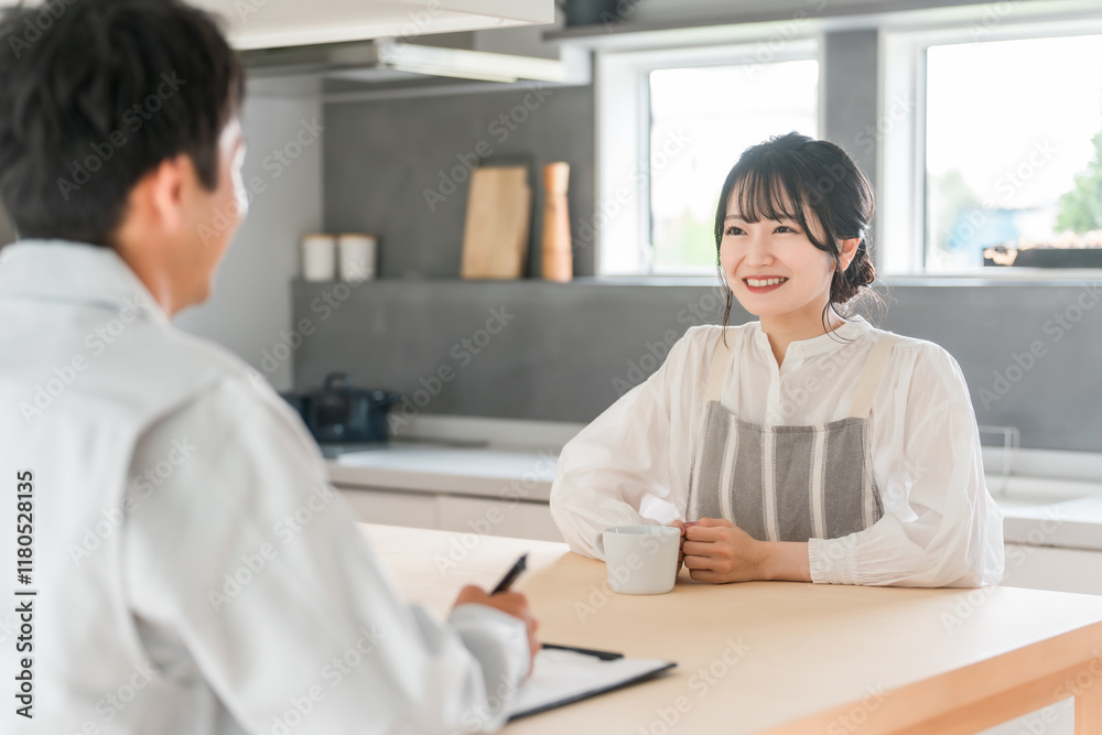 Obraz premium 契約書・同意書の説明を聞く主婦と説明する作業着姿の営業マンの男性 