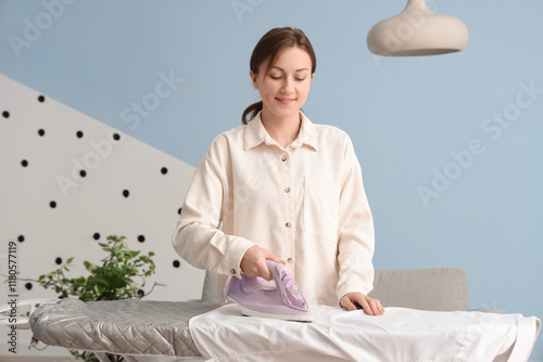 Young woman ironing white s...