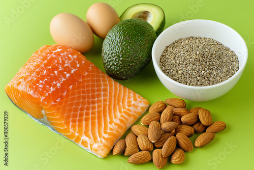 Keto Diet Healthy Food Concept with Salmon Avocado Eggs Nuts Seeds on Bright Green Background Top View






