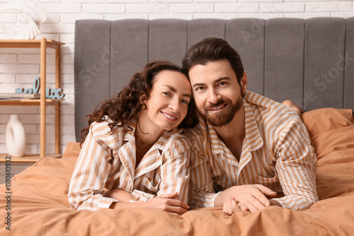 Happy couple in pajamas lyi...