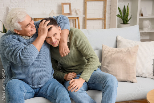 Mature man hugging his son ...