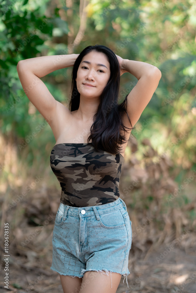 Portrait of sexy asian woman in a military print strapless dress, camping in the forest concept. Portrait of sexy asian woman in a military print strapless dress, camping in the forest concept.
