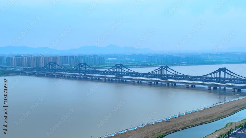 Aerial view showcasing Xinpengbu Bridge over the serene waters of Hangzhou's river landscape at twilight Aerial view showcasing Xinpengbu Bridge over the serene waters of Hangzhou's river landscape at twilight