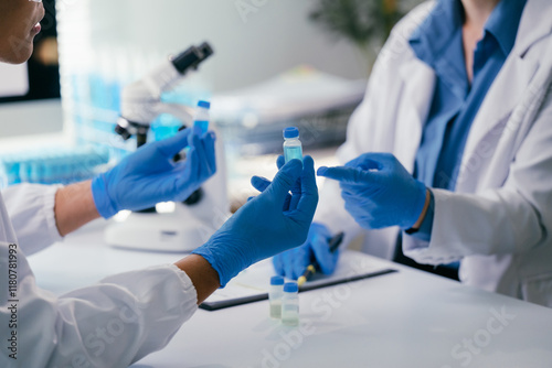 Foto Two scientists wearing lab coats and gloves are examining and comparing samples