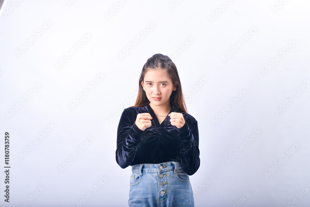 A young Asian Woman in a Black Velvet Top and Denim Jeans making expressive gestures Isolated on white background A young Asian Woman in a Black Velvet Top and Denim Jeans making expressive gestures Isolated on white background