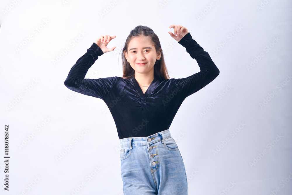 A young Asian Woman in a Black Velvet Top and Denim Jeans making expressive gestures Isolated on white background A young Asian Woman in a Black Velvet Top and Denim Jeans making expressive gestures Isolated on white background