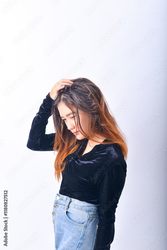 A young Asian Woman in a Black Velvet Top and Denim Jeans making expressive gestures Isolated on white background A young Asian Woman in a Black Velvet Top and Denim Jeans making expressive gestures Isolated on white background