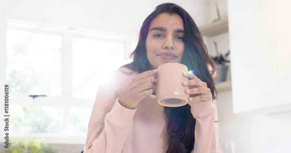 Smiling woman enjoying coffee at home, sunlight streaming through window Smiling woman enjoying coffee at home, sunlight streaming through window