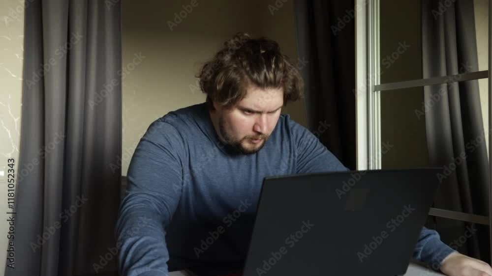 Angry man working on laptop, hatred for technical struggles, typing in a remote workspace. Angry man working on laptop, hatred for technical struggles, typing in a remote workspace.