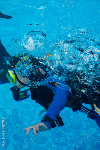 Varna, Bulgaria: 10.02.2022. A diver underwater during an underwater sports competition. Balloons are coming out of the diving equipment. Photographed in a pool from above the water. photo