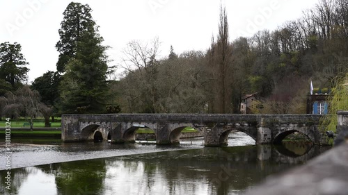 A bridge spans a river with a view of trees in the background