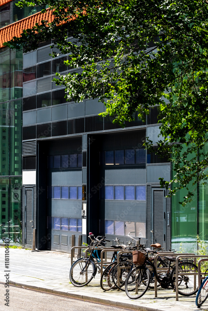 A striking image featuring a bicycle parking area near a contemporary building, reflecting modern urban design elements and vibrant greenery in Amsterdam A striking image featuring a bicycle parking area near a contemporary building, reflecting modern urban design elements and vibrant greenery in Amsterdam