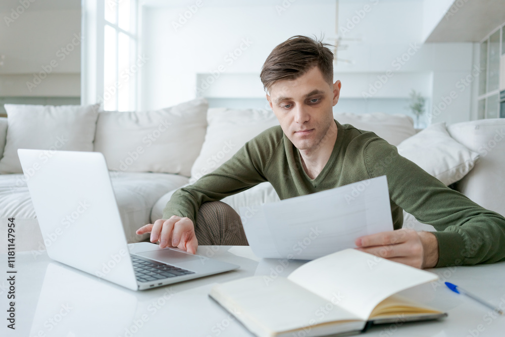 Man is sitting at a table with a laptop and a notebook Man is sitting at a table with a laptop and a notebook
