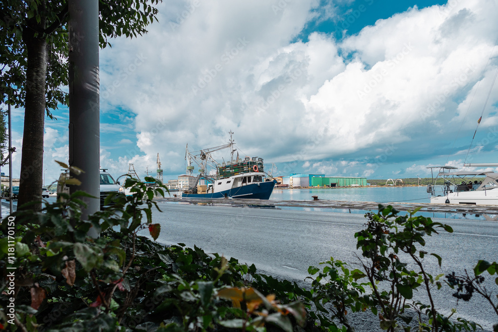 Single fishing ship is resting at a pier in Pula city harbor, peaceful sea and low traffic around