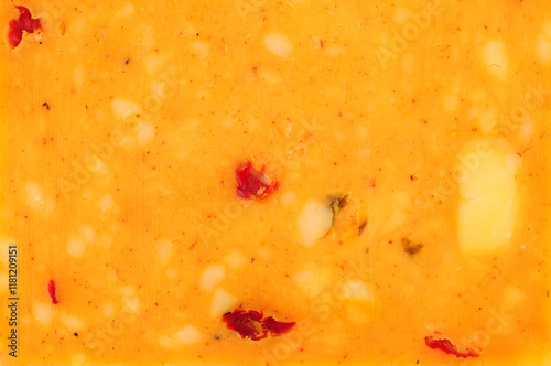 Cheddar cheese slice with mixed peppers and spices flavour background texture