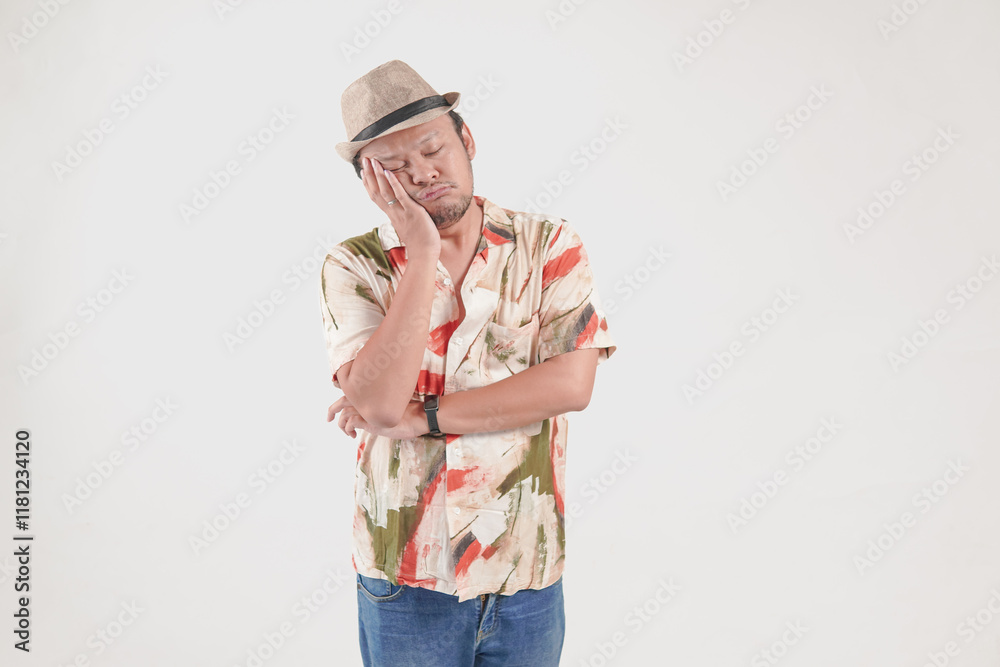 Tired young Asian tourist man feeling sleepy and depressed, leaning on his hand. Tired young Asian tourist man feeling sleepy and depressed, leaning on his hand.