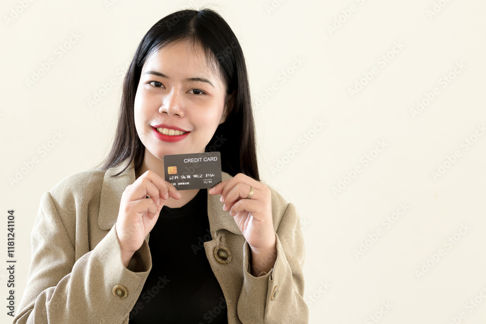 Businesswoman smiling and holding credit card on light yellow isolated background Businesswoman smiling and holding credit card on light yellow isolated background
