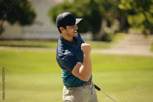 Male golfer celebrating a successful putt with a fist pump and smile