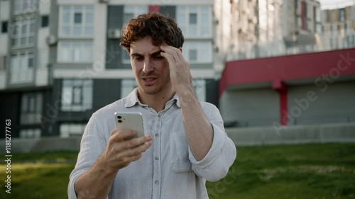 Caucasian man holding mobile phone smartphone bad news loss failure frustrated male angry online guy businessman city outdoor upset problem internet trouble unhappy business error annoyed urban losing