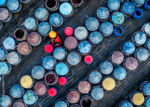 Aerial view of vibrant circles of clay urns and a worker with a yellow hat in a food production scene, Ham Tien, Vietnam. photo