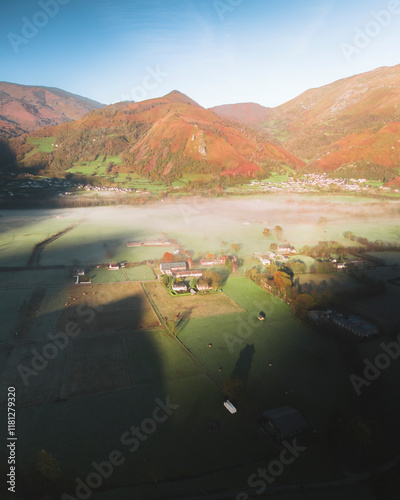 Aerial view of misty morning landscape with mountains, valley, and fields, Accous, France. photo