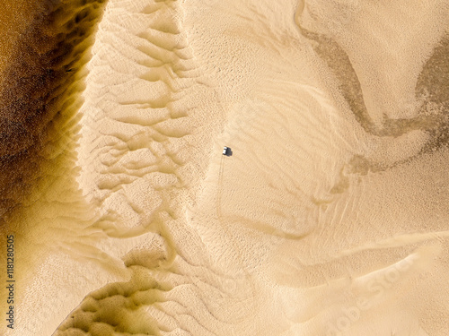 Aerial view of a car on the sand with beautiful patterns and textures in the vast dunes, Fraser Island, Queensland, Australia. photo